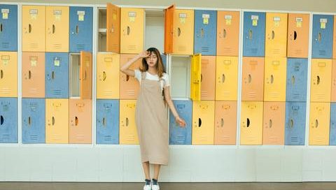 An Image of How to keep your kids active this summer when school's out. The girl is wearing a summer dress with vacant lockers at the back